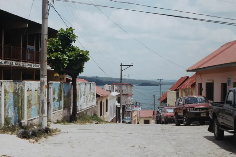 Calle de Flores, en Petén, Guatemala, con casas bajas y el lago al fondo