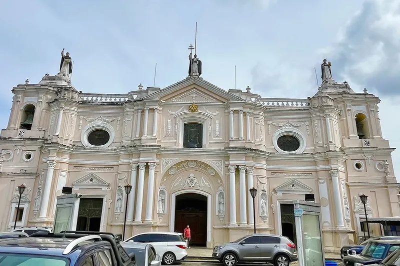 Fachada de la iglesia de Santo Domingo en la Ciudad de Guatemala con autos estacionados al frente
