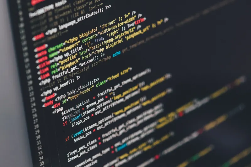 Líneas de código PHP en colores sobre el fondo oscuro de la pantalla de una laptop